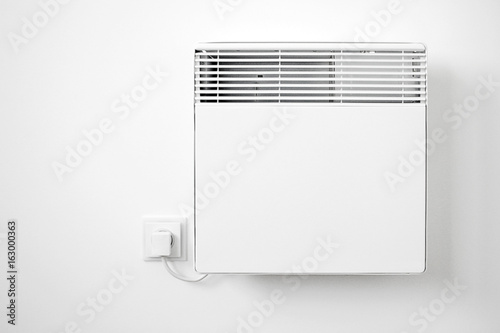 Modern white electric radiator on the wall