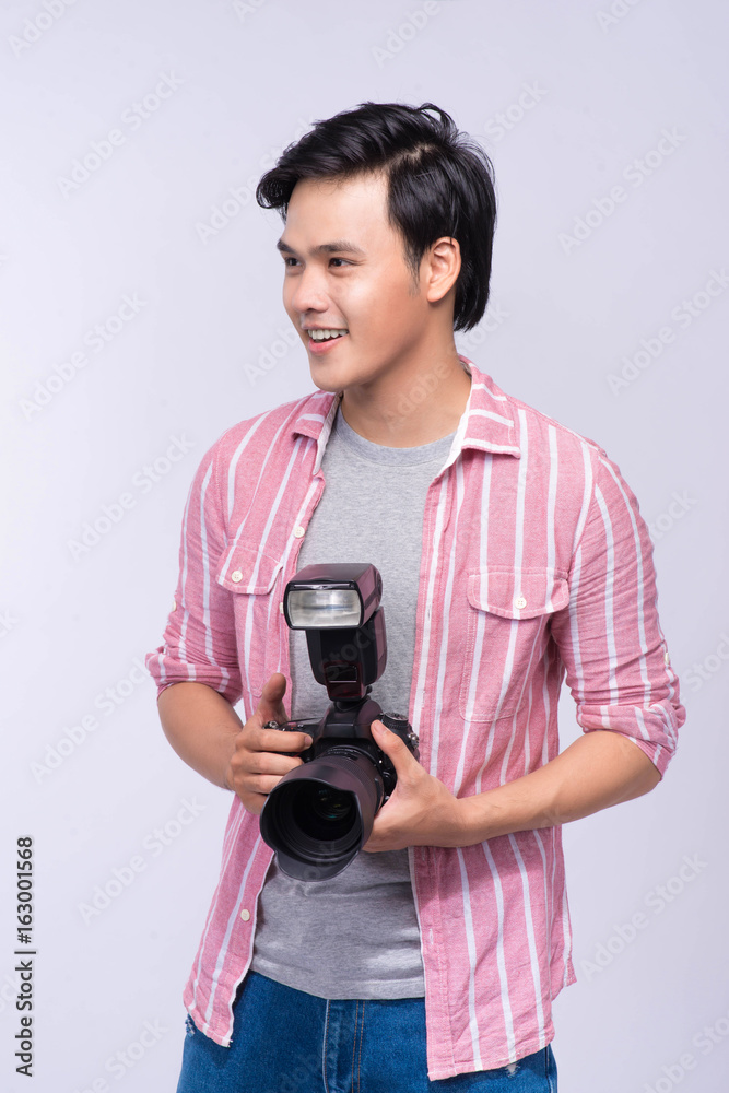 Young asian photographer holding digital camera, while working in studio Young asian photographer holding digital camera, while working in studio