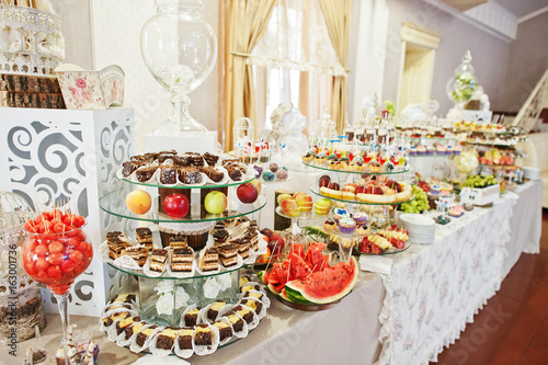 Gorgeous-looking wedding table with various beverages, delicious dishes, fruits and decorations. © AS Photo Family