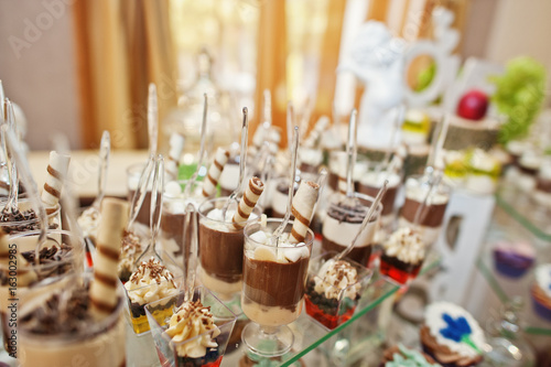 Gorgeous-looking wedding table with various beverages, delicious dishes, fruits and decorations.