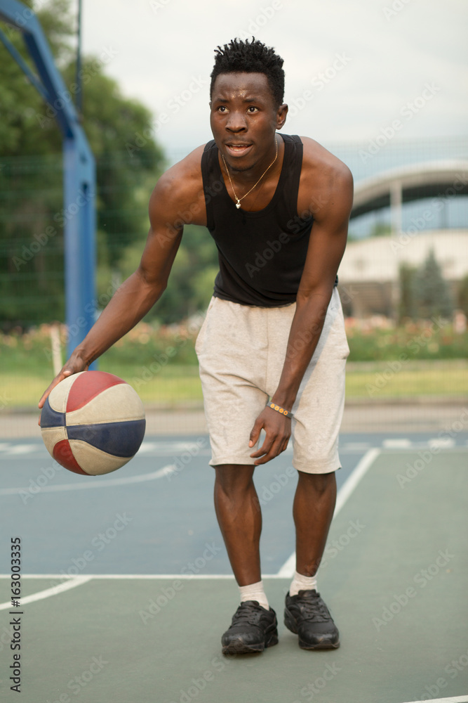 African american man on basketball court dribbling with ball. Real and authentic activity. African american man on basketball court dribbling with ball. Real and authentic activity.