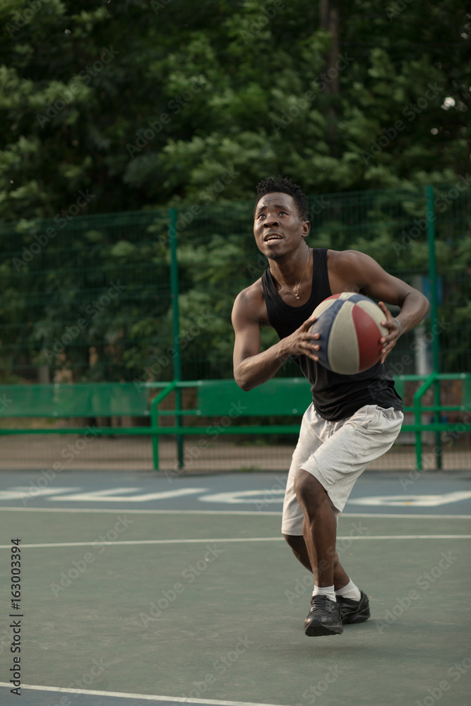 African american man plays on street basketball court. Real and authentic activity. African american man plays on street basketball court. Real and authentic activity.