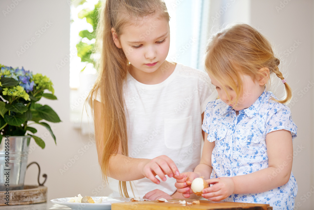 Fototapeta premium Zwei Mädchen schälen Eier zu Ostern