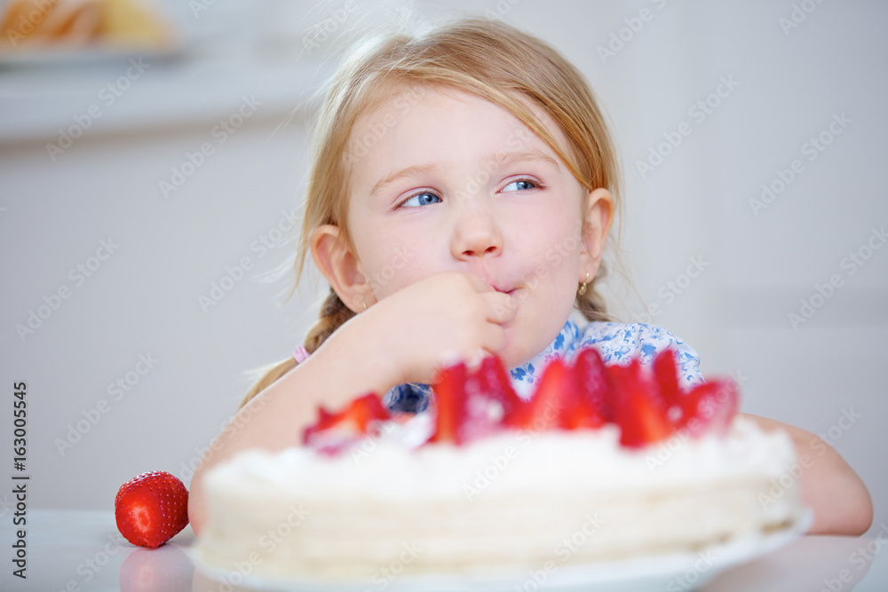 Mädchen nascht heimlich von Erdbeerkuchen Mädchen nascht heimlich von Erdbeerkuchen