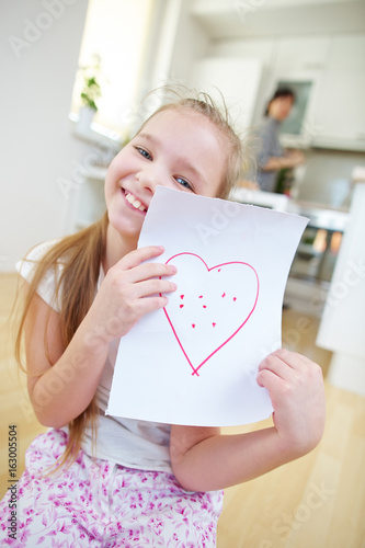 Mädchen zeigt Papier mit rotem Herz