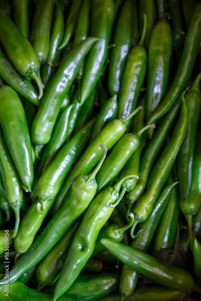 A lot of hot spicy chili green red peppers background