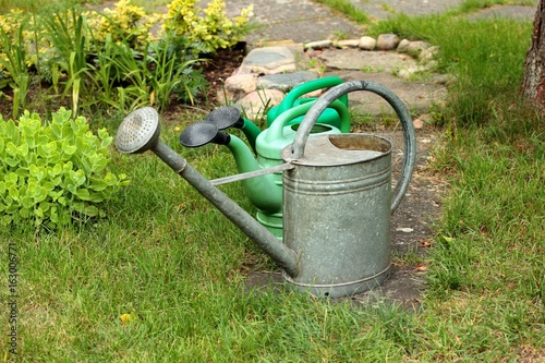 Old metal watering can on the lawn