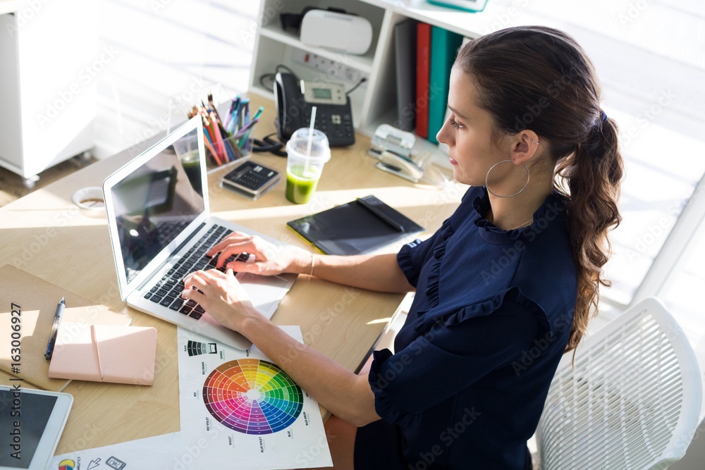 Female executive working over laptop at her desk Female executive working over laptop at her desk
