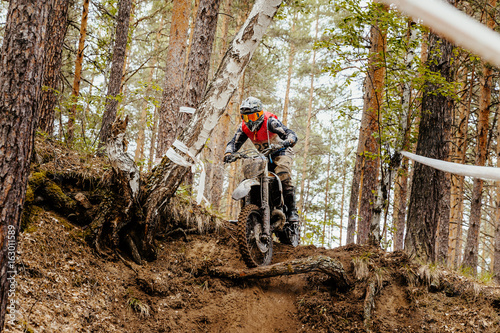 motorcycle enduro racing motocross in forest downhill