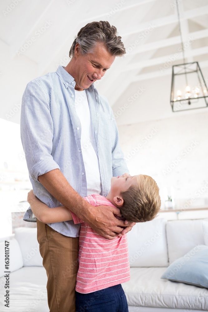 Obraz premium Happy father and son embracing each other in living room