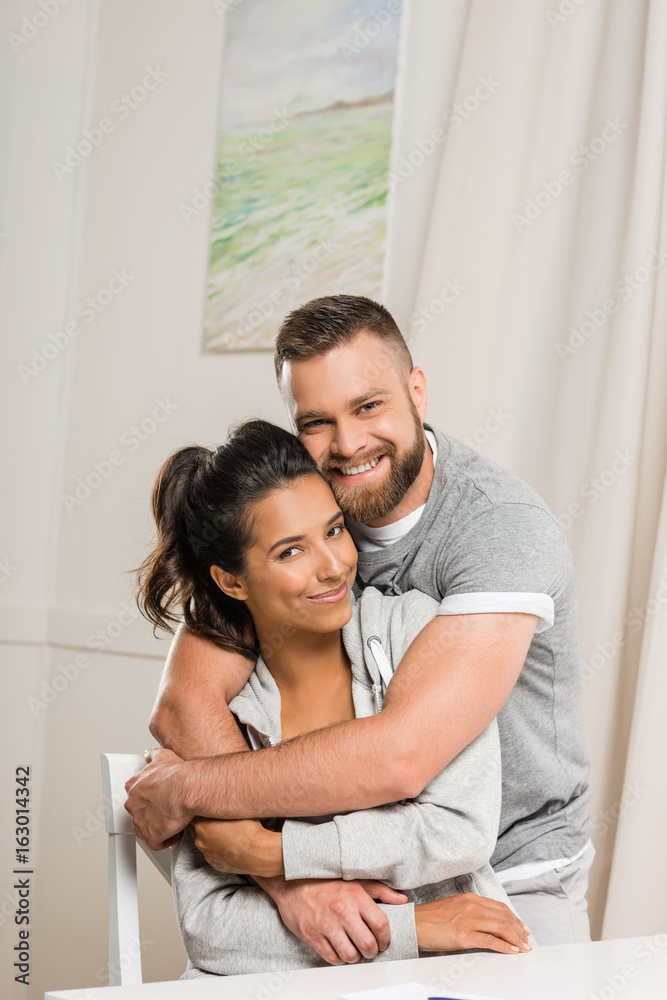 portrait of happy man looking at camera while hugging woman portrait of happy man looking at camera while hugging woman