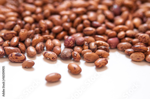 Dry brown beans on white background.