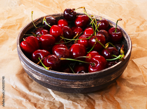 Closeup of dark red cherries in earthenware bowl