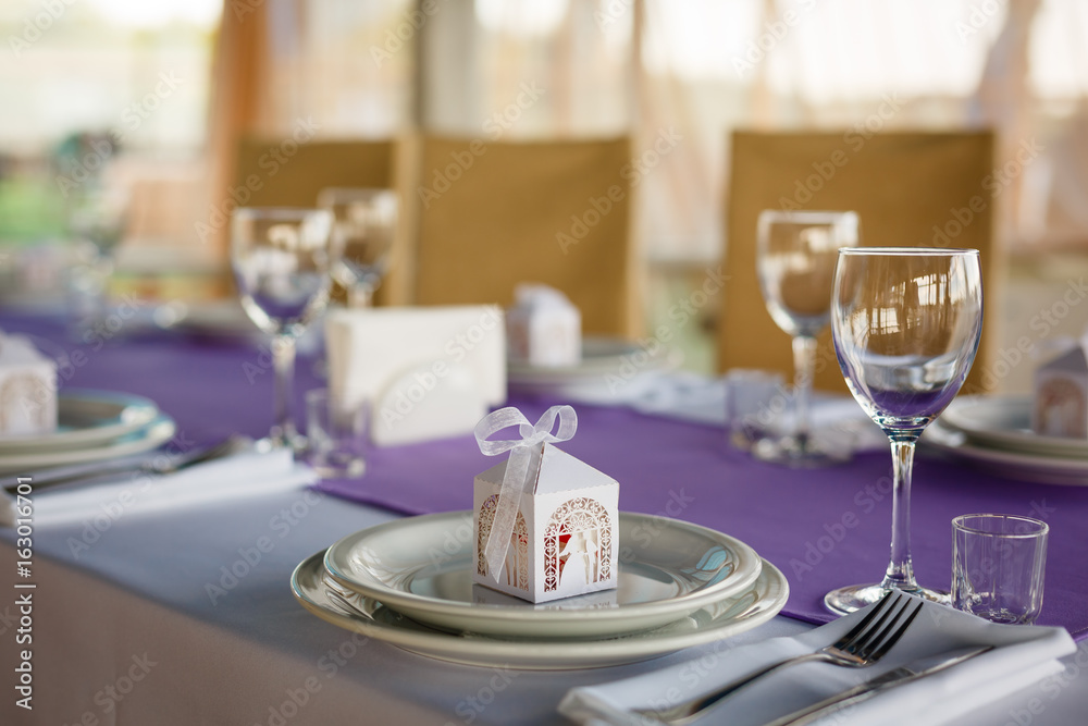Fototapeta premium Beautiful flowers, candles and bonbonniere on table in wedding day.Blue color decoration tablecloth