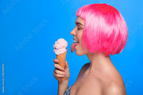 Side view of woman licking ice cream photo