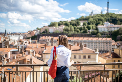 Young woman with red bag enjoying great view on Lyon city in France