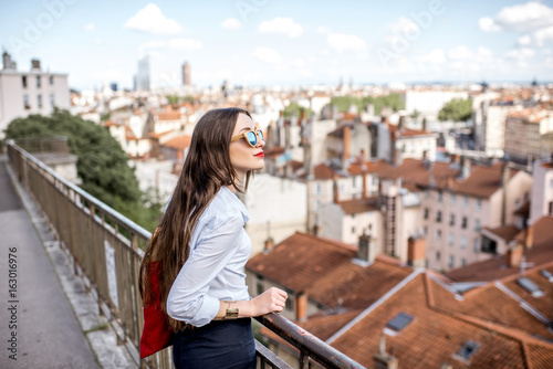Young woman with red bag enjoying great view on Lyon city in France