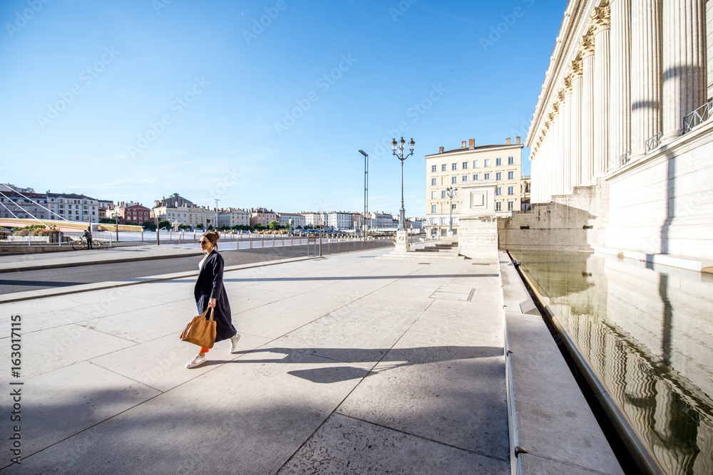 Beautiful view on the square with woman walking near the palace of the twenty-four columns in Lyon city