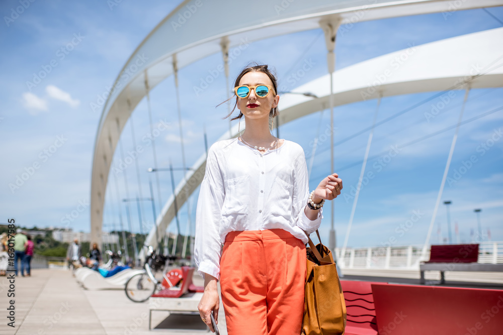Elegant woman walking on the modern bridge in Lyon city Elegant woman walking on the modern bridge in Lyon city