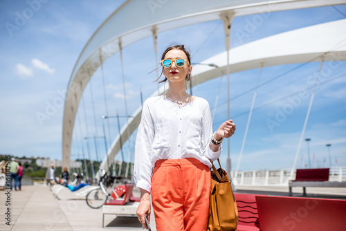 Elegant woman walking on the modern bridge in Lyon city