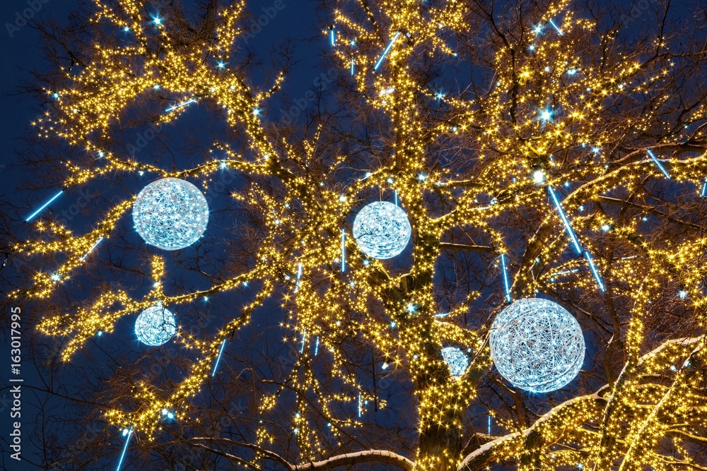 New Year tree decorated with balls with illuminated illumination in the evening