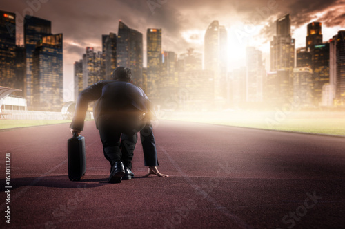 businessman on a track ready for race in business photo