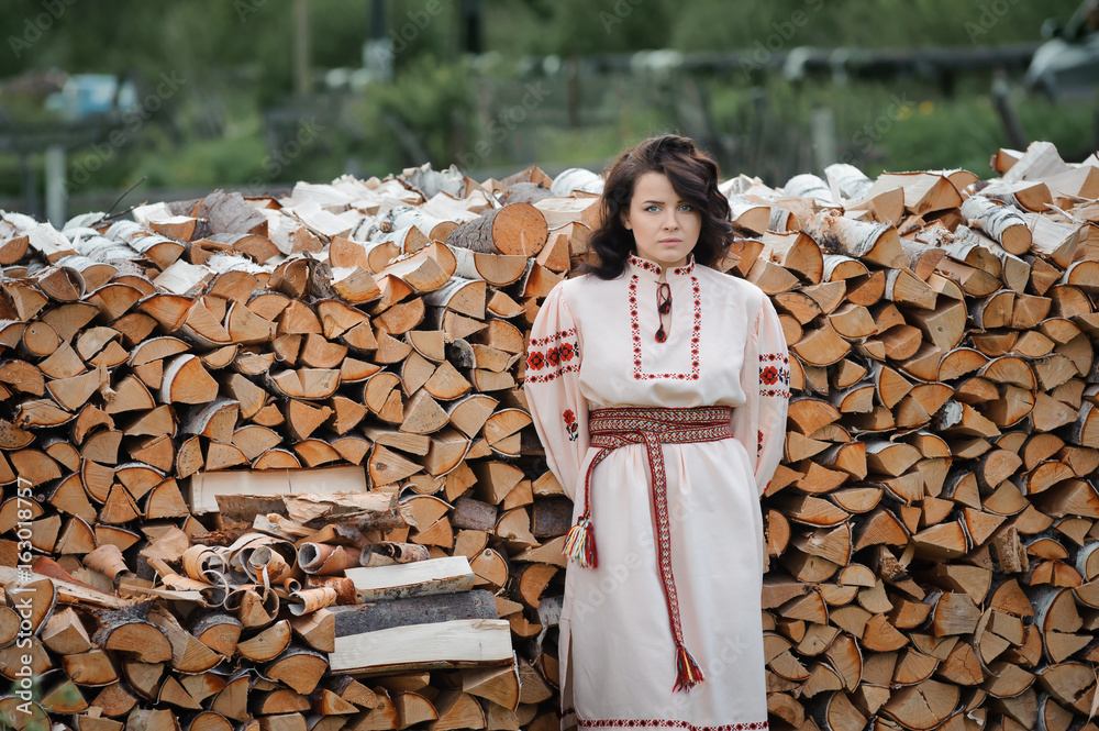 Portrait of a beautiful girl in Slavic clothes on the background