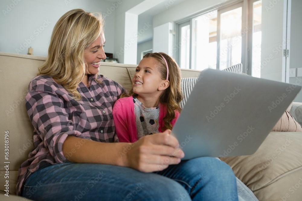 Mother and daughter using laptop in the living room Mother and daughter using laptop in the living room