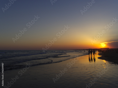 People walking on the shore at twilight