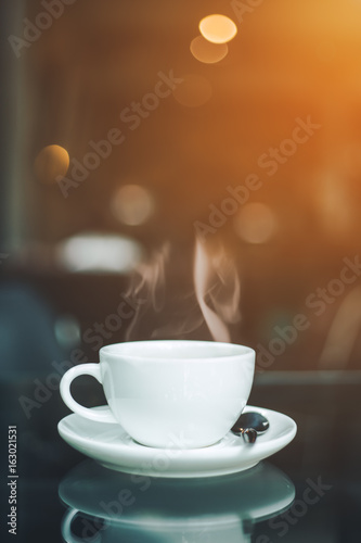 cup of coffee and smoke on table in cafe.