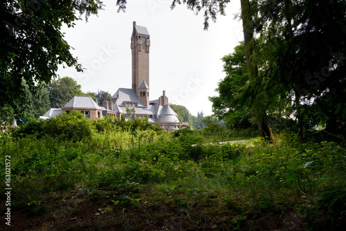 Lodge St. Hubertus, shot from behind some trees, at National Park De Hoge Veluwe, The Netherlands.