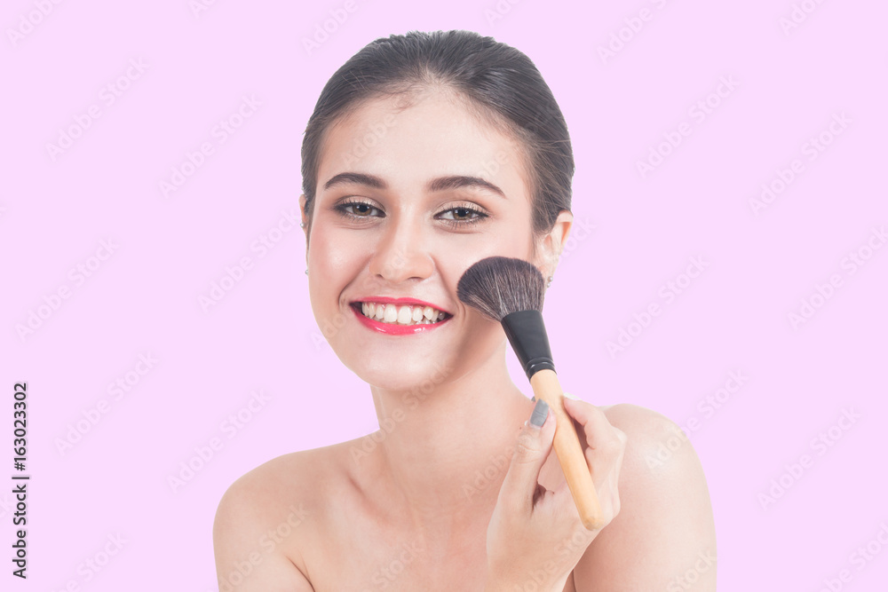 Woman holding make-up brushes on pink background Woman holding make-up brushes on pink background