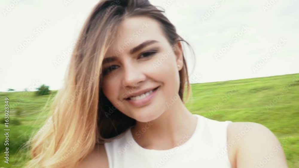 Young woman spinning with the camera on the meadow slow motion Young woman spinning with the camera on the meadow slow motion