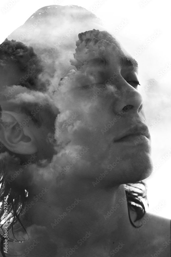 Double exposure portrait of a young fit man, pensive yet relaxed blended seamlessly with a cloudy ocean sky Double exposure portrait of a young fit man, pensive yet relaxed blended seamlessly with a cloudy ocean sky