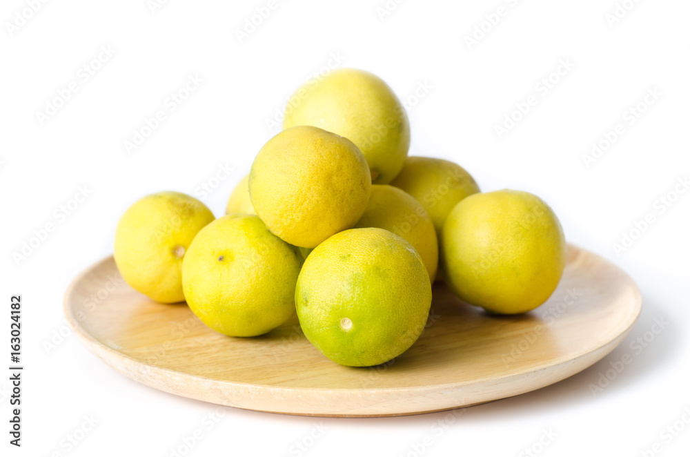 Fresh lime on wooden plate isolated on white background,citrus fruit Fresh lime on wooden plate isolated on white background,citrus fruit
