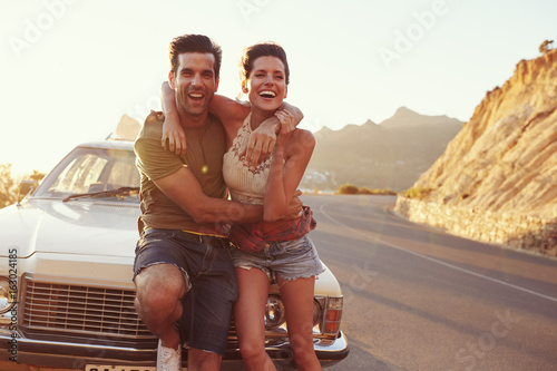 Portrait Of Young Couple Standing Next To Classic Car