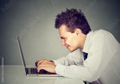 Happy man working on laptop computer