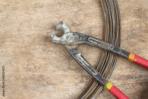 Wire cutter on wood background.
