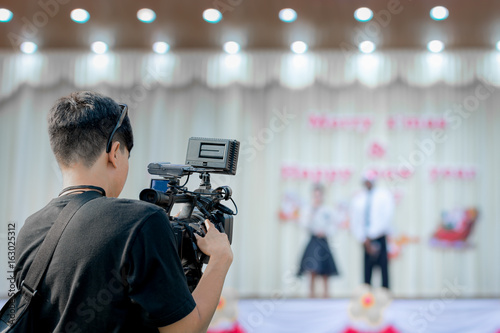Covering an event on stage with a video camera. © redkphotohobby