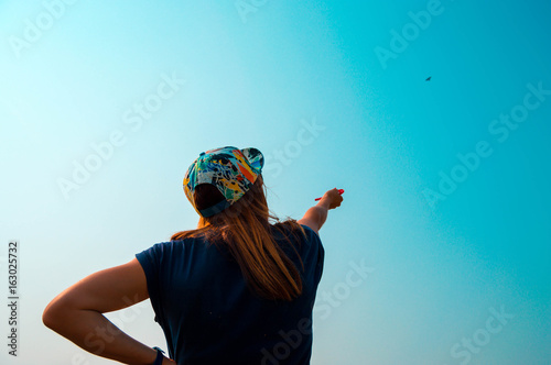 Little girl flying a kite at sky