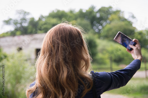 The girl is making a selfie in the park