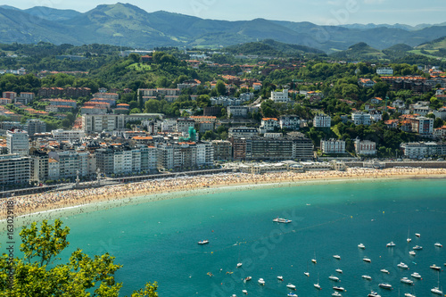 Panoramic view of San Sebastian beach de la Concha and boats in the harbor.