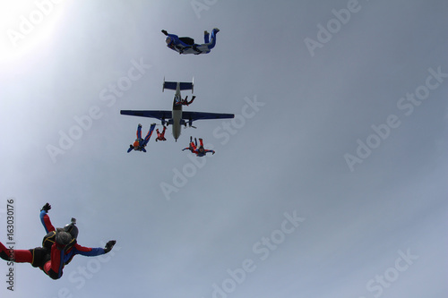 Skydivers are jumping out of a plane.