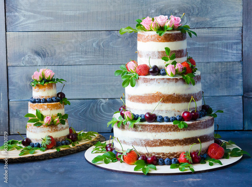 Naked wedding cake decorated with berries and flowers
