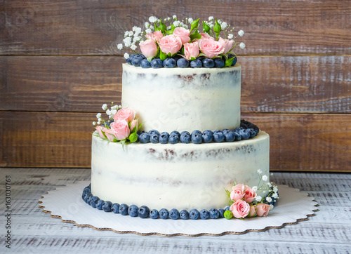 Gentle wedding cake with blueberry and roses