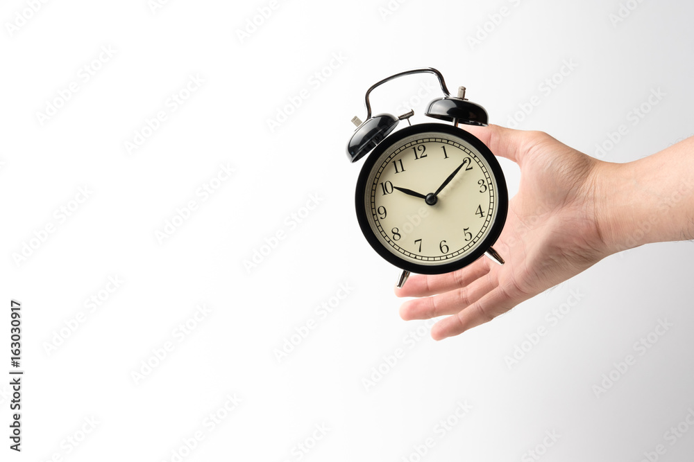 grab the black retro alarm clock flying on the air with men's hand on white background grab the black retro alarm clock flying on the air with men's hand on white background