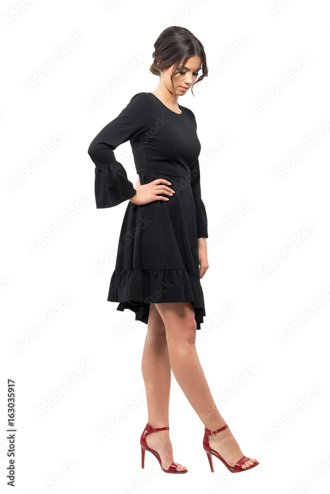 Passionate young latin female dancer looking down at shoes. Full body length portrait isolated on white studio background. Passionate young latin female dancer looking down at shoes. Full body length portrait isolated on white studio background.