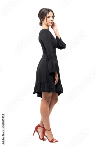 Side view of passionate Hispanic dancer relaxing and touching hair looking at camera. Full body length portrait isolated on white background. 