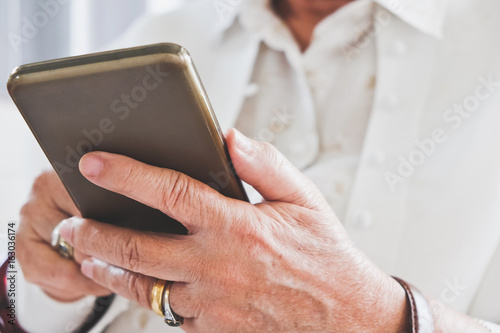 close up image of Senior woman using her mobile phone background.  An idea of modern lifestyle  communication telecommunication connectivity  social networking