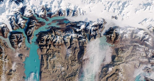 Very high-altitude overflight aerial of snowpack and glacial lakes in the Southern Patagonian alps. Clip loops and is reversible. Elements of this image furnished by USGS/NASA Landsat